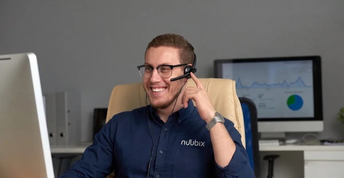 Person with a headset handling support at a monitor